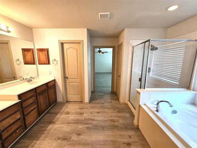 a spacious bathroom with a tub sink and mirror