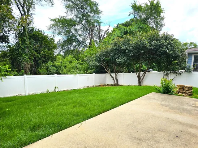 a view of yard with grass and trees