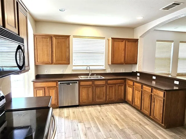 a kitchen with stainless steel appliances granite countertop a sink stove and cabinets