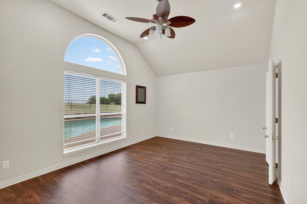 2828 Bennett Road Howe, TX 75459 - Photo 15 of 39 an empty room with wooden floor chandelier fan and windows