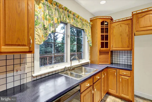 a kitchen with stainless steel appliances granite countertop a stove a sink dishwasher and a refrigerator with wooden floor