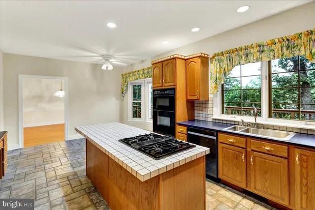a view of an empty room with a window and kitchen view