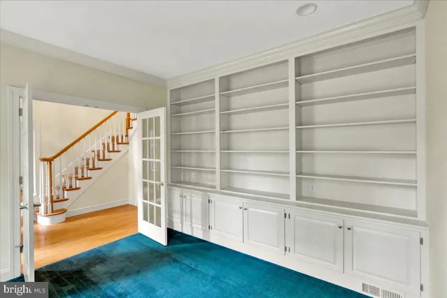 a view of an empty room with wooden floor and entryway