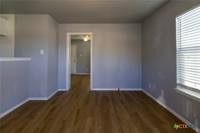 a view of a room with wooden floor and a window
