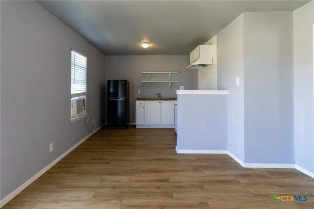 a view of a kitchen with a refrigerator and a window