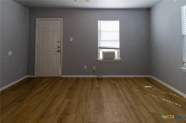 a view of a room with wooden floor and window
