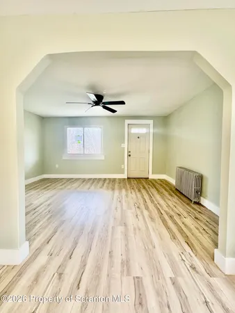 a view of empty room with wooden floor