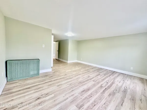 a view of an empty room with wooden floor