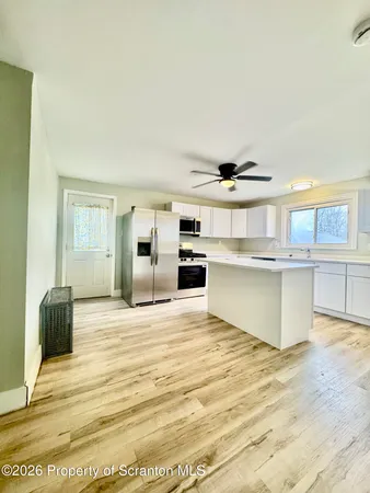 a view of kitchen with stainless steel appliances kitchen island a stove a refrigerator sink and cabinets