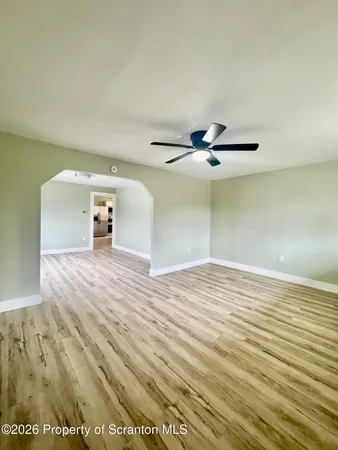 a view of empty room with wooden floor