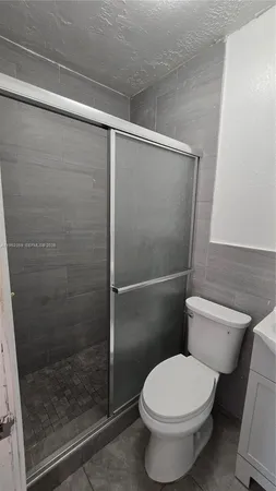a white toilet sitting next to a shower