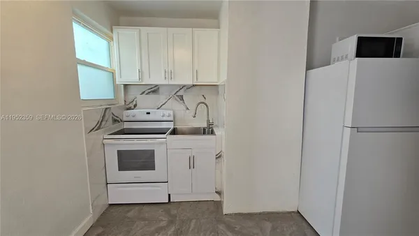 a kitchen with stainless steel appliances white cabinets and a refrigerator