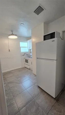 a kitchen with a refrigerator and a stove top oven