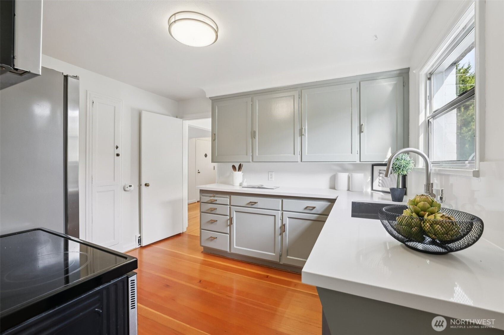 819 Northwest 80th Street Seattle, WA 98117 - Photo 12 of 37 a kitchen with stainless steel appliances granite countertop a sink a stove and cabinets