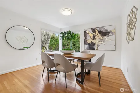 a view of a dining room with furniture a potted plant and wooden floor