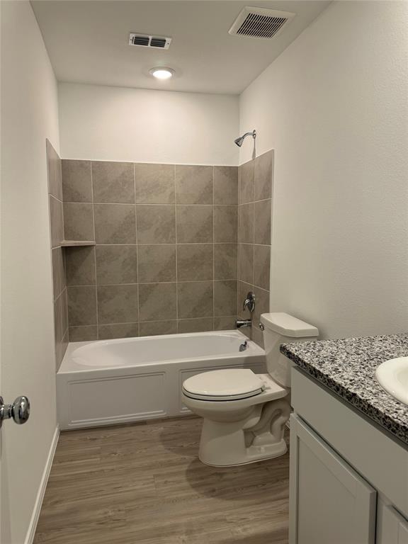 11719 Bone Spg Drive Rhome, TX 76078 - Photo 16 of 18 a bathroom with a granite countertop toilet a sink and a bathtub