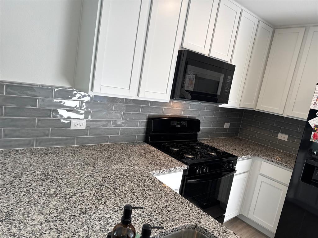 11719 Bone Spg Drive Rhome, TX 76078 - Photo 6 of 18 a kitchen with a stove and a microwave