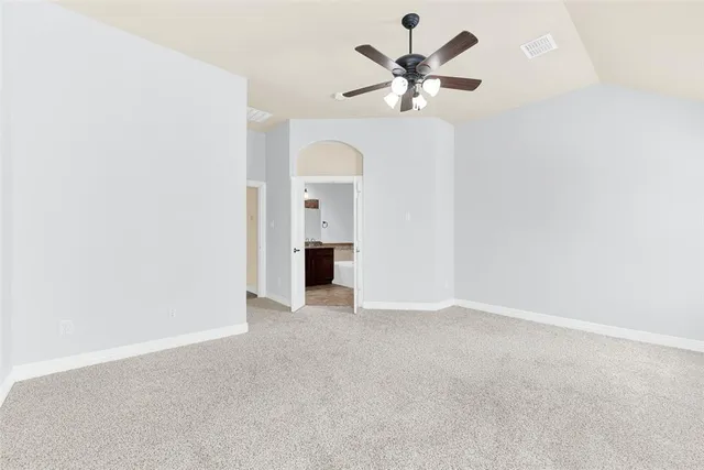 an empty room with a chandelier fan and a ceiling fan