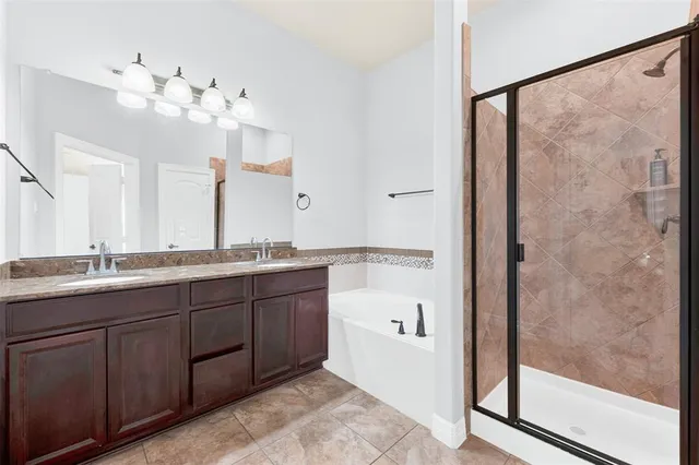 a bathroom with a double vanity sink mirror and shower
