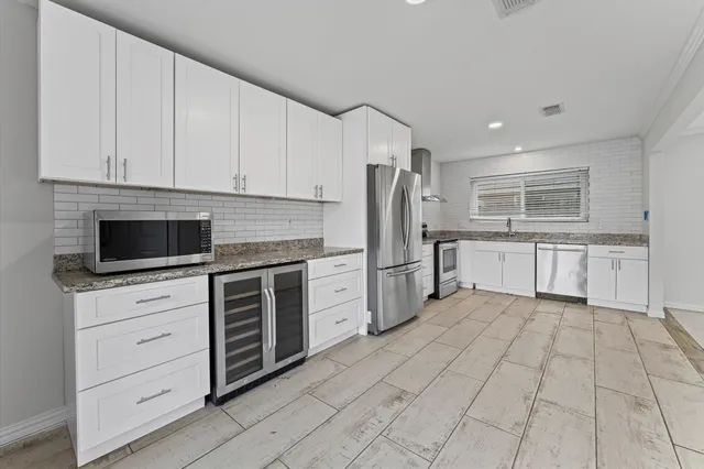 a kitchen with stainless steel appliances a refrigerator sink and stove