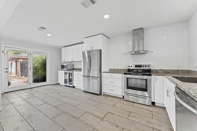 a kitchen with stainless steel appliances a refrigerator sink stove and cabinets
