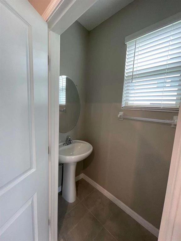31993 Blue Passing Loop Wesley Chapel, FL 33545 - Photo 15 of 17 a bathroom with a sink a toilet and a window