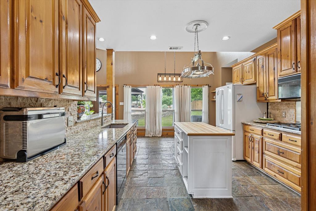 6251 Hayes Road Midlothian, TX 76065 - Photo 13 of 30 a kitchen with stainless steel appliances granite countertop a stove oven and a refrigerator