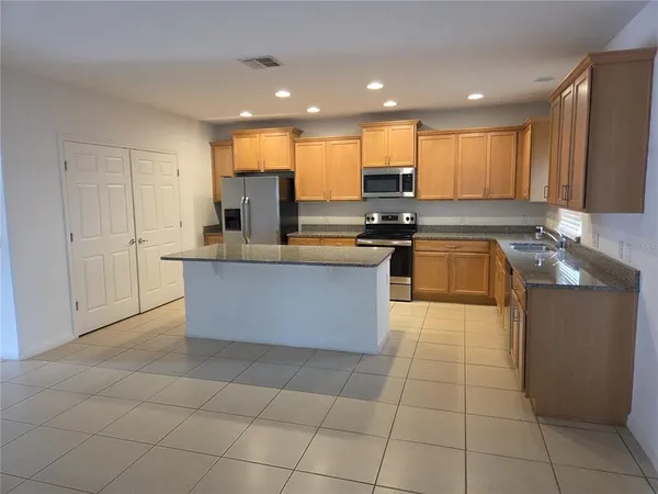 a kitchen with a sink a counter top space cabinets and stainless steel appliances