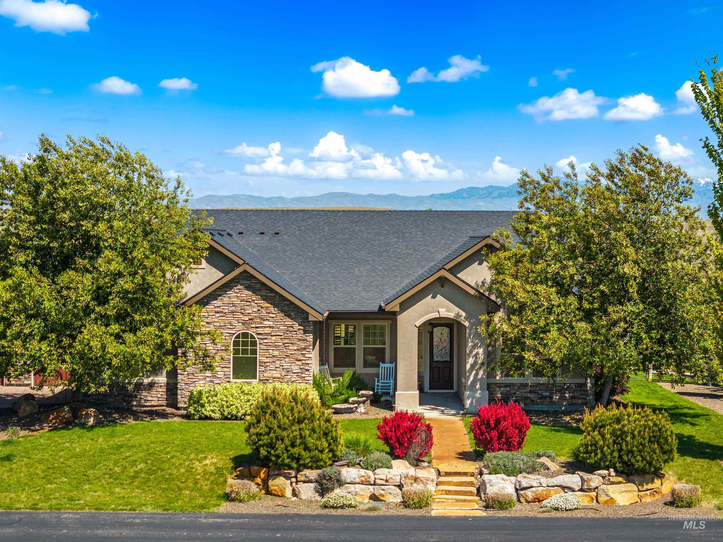 7521 North Grand Ridge Lane Eagle, ID 83616 - Photo 2 of 50 Stone and stucco exterior residence featuring a dark shingle roof