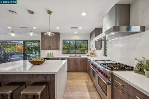 a kitchen with kitchen island a stove and a sink