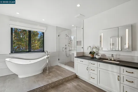 a spacious bathroom with a granite countertop sink a toilet a mirror and bathtub