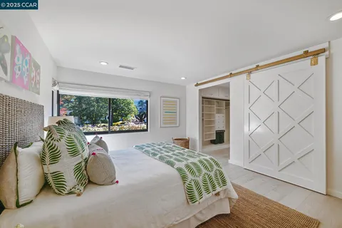 a bathroom with a granite countertop sink a toilet a large mirror and shower