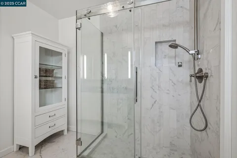 a bathroom with a granite countertop shower a mirror and a sink