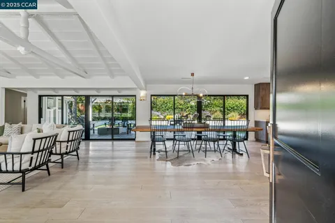 an dining room with furniture water view and floor to ceiling window