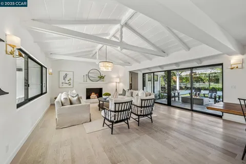 a living room with furniture a fireplace and a large window