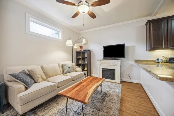 a kitchen with stainless steel appliances granite countertop a stove top oven a sink a dining table and chairs with wooden floor