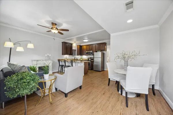 a living room with furniture a wooden floor and a dining table