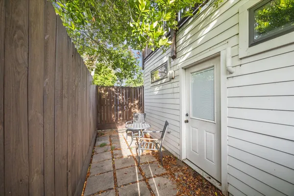 a living room with stainless steel appliances granite countertop furniture wooden floor and a kitchen view