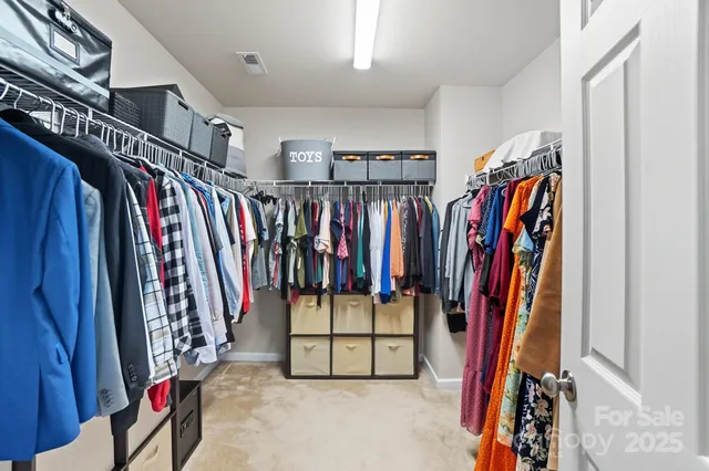 a view of walk in closet with clothes