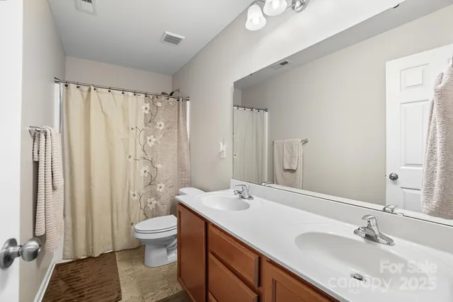 a bathroom with a double vanity sink toilet and shower