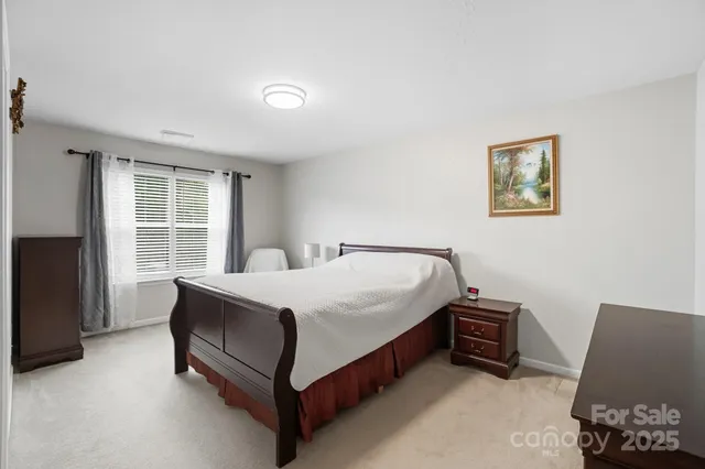 a bed sitting in a bedroom next to a window