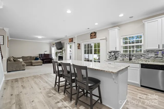 a kitchen with stainless steel appliances granite countertop a table and chairs in it