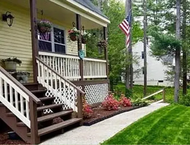 a view of a house with a small yard and wooden fence