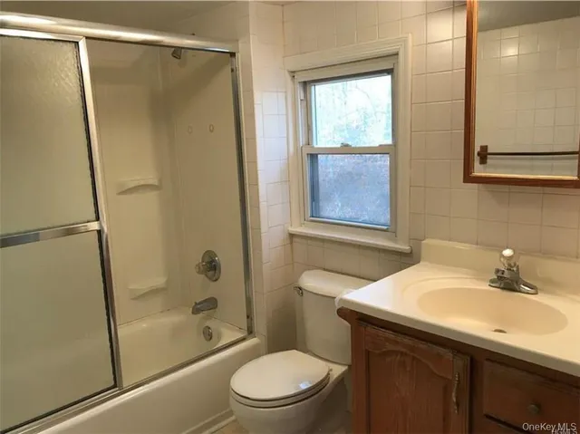 a bathroom with a sink a mirror toilet and shower