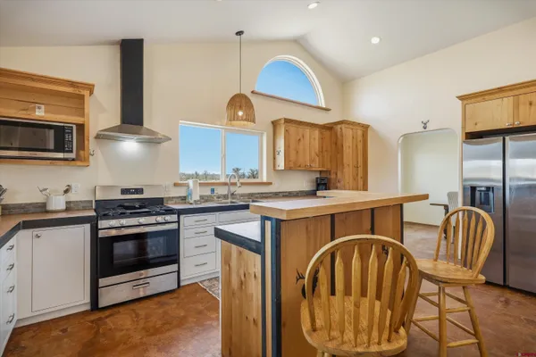 a kitchen with stainless steel appliances granite countertop a stove a sink and a microwave