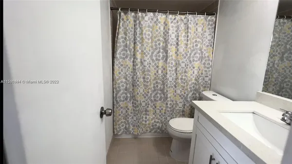 a white toilet sitting next to a shower curtain