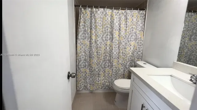 a white toilet sitting next to a shower curtain