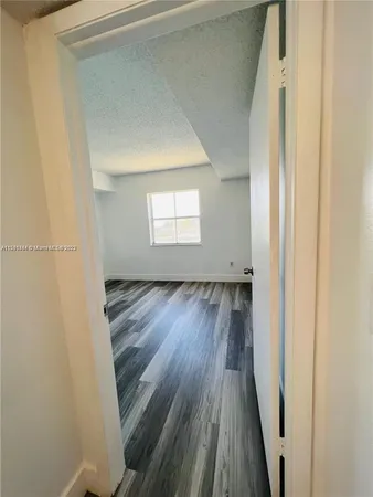 a view of a room with wooden floor and a window