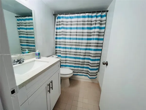 a bathroom with a sink a toilet and shower curtain