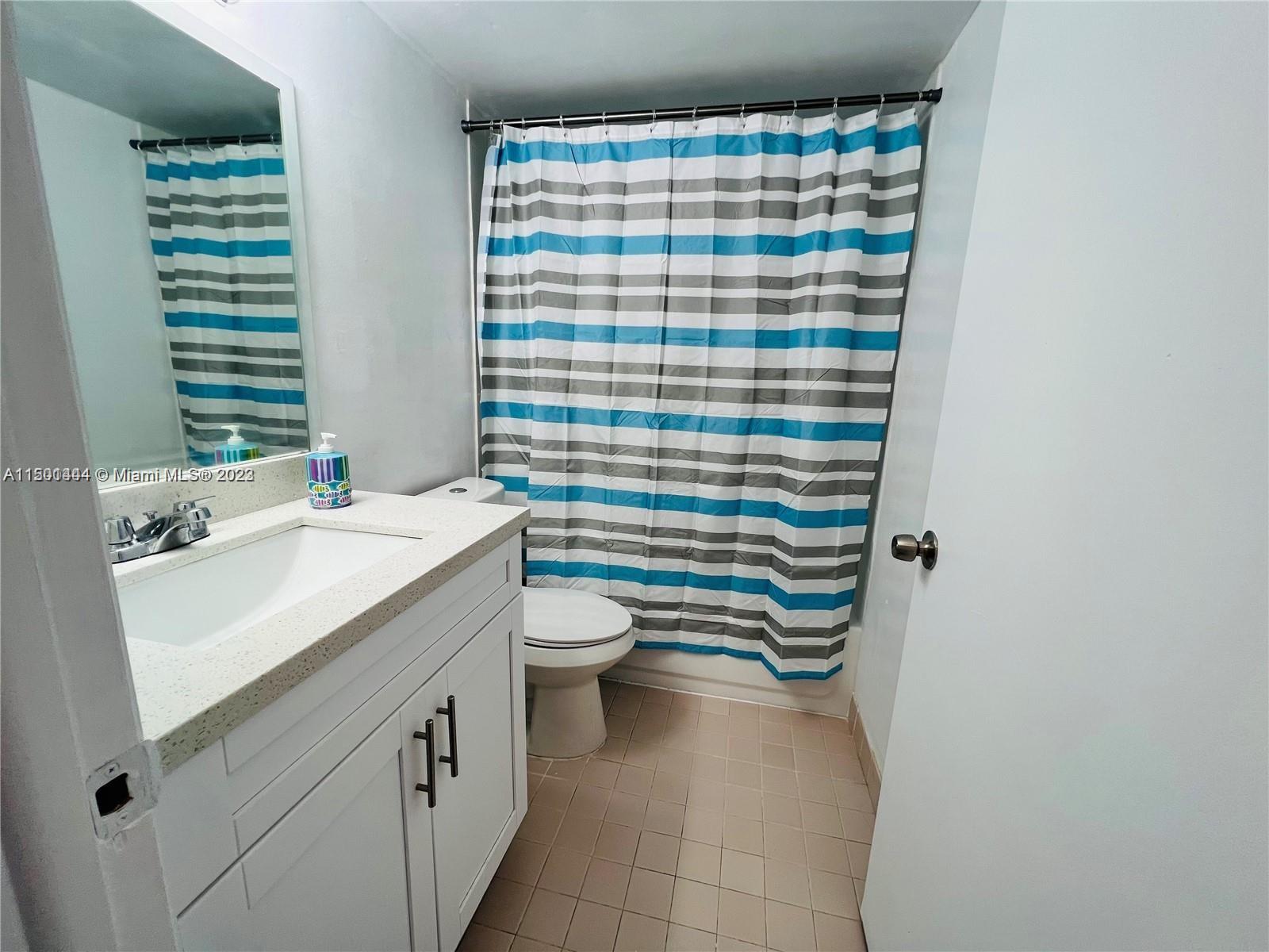 8260 Southwest 210th Street, Unit 220 Cutler Bay, FL 33189 - Photo 8 of 21 a bathroom with a sink a toilet and shower curtain